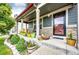 Inviting front porch featuring a cozy seating area and stylish decor at 1824 Asoka St, Strasburg, CO 80136