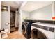 Convenient laundry room with a washer and dryer, a tile shower with stone tile, and shelving for storage at 1824 Asoka St, Strasburg, CO 80136