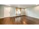 Spacious living room with hardwood floors, large window, and neutral paint, awaiting personal touch at 1824 Asoka St, Strasburg, CO 80136