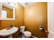 Inviting powder room with bright yellow walls, a pedestal sink, and modern fixtures at 1824 Asoka St, Strasburg, CO 80136