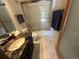 Bright bathroom with tiled floor, granite vanity, a glass shower door, and new sink at 24226 Currant Dr, Golden, CO 80401