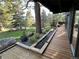 Inviting wooden deck with river rock feature, lush landscaping, and picturesque outdoor views at 24226 Currant Dr, Golden, CO 80401
