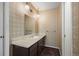 Cozy bathroom featuring patterned wallpaper, a single sink vanity with storage, and updated lighting fixtures at 2949 Vivian St, Wheat Ridge, CO 80215