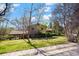 Exterior view of this home with an attached carport surrounded by trees and lush green lawn at 2949 Vivian St, Wheat Ridge, CO 80215