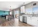 Modern kitchen with stainless steel appliances, white cabinets, and an adjacent dining area at 14803 E 117Th Pl, Brighton, CO 80603