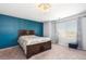 Comfortable main bedroom with a large bed, accent wall, soft carpet, and natural light at 14803 E 117Th Pl, Brighton, CO 80603
