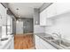 Galley kitchen featuring white cabinets, stainless steel sink, and updated appliances at 8055 W Eastman Pl # 104, Lakewood, CO 80227