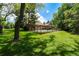 A spacious, lush green backyard enclosed by a black metal fence with mature trees at 39 Sedgwick Dr, Cherry Hills Village, CO 80113