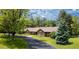 Charming single-story home featuring a beautifully landscaped front yard with mature trees and a long driveway at 39 Sedgwick Dr, Cherry Hills Village, CO 80113
