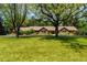 Spacious single-story home with a well-manicured lawn and mature trees, providing shade and curb appeal at 39 Sedgwick Dr, Cherry Hills Village, CO 80113