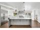 Bright kitchen with white cabinets, stainless appliances, large island, and hardwood flooring at 39 Sedgwick Dr, Cherry Hills Village, CO 80113