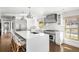 Stylish kitchen featuring a large island, stainless steel appliances, and a view of the staircase at 39 Sedgwick Dr, Cherry Hills Village, CO 80113