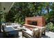 Charming outdoor fireplace and seating area nestled among mature trees at 39 Sedgwick Dr, Cherry Hills Village, CO 80113