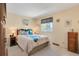 Cozy bedroom with a decorative comforter set, warm lighting, and a pleasant window view at 10520 W 101St Pl, Westminster, CO 80021