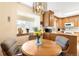Bright eat-in kitchen area featuring wood cabinets, a round table, and a sunlit window at 10520 W 101St Pl, Westminster, CO 80021