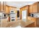 Spacious kitchen featuring wood cabinets, granite countertops, and modern appliances at 10520 W 101St Pl, Westminster, CO 80021