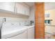 Well-equipped laundry room with washer, dryer, and storage cabinets at 10520 W 101St Pl, Westminster, CO 80021