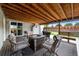 Inviting back porch with seating, a fire pit, wood ceiling and view of backyard landscaping at 11323 Albion St, Thornton, CO 80233