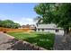 Well-maintained backyard with green grass, brick-lined flowerbeds, a privacy fence, and mature trees at 11323 Albion St, Thornton, CO 80233