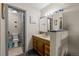 Cozy half bathroom adjacent to the main bathroom featuring warm wood cabinetry at 11323 Albion St, Thornton, CO 80233