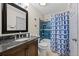 This bathroom features a modern vanity, a bathtub with shower, and bright blue tiling at 11323 Albion St, Thornton, CO 80233