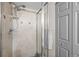 Shower featuring tiled walls, modern shower head, glass door, and convenient towel rack at 11323 Albion St, Thornton, CO 80233