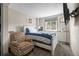 Bedroom with colorful side chair, window, mounted TV, and plenty of natural light at 11323 Albion St, Thornton, CO 80233
