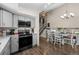 Modern kitchen with grey cabinets, granite counters, stainless appliances and easy access to dining area at 11323 Albion St, Thornton, CO 80233