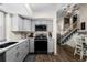 Grey kitchen with granite counters, updated appliances, hardwood floors, and access to the second story at 11323 Albion St, Thornton, CO 80233