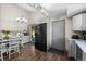Open floorplan with kitchen and dining area, stainless fridge, hardwood floors and granite counters at 11323 Albion St, Thornton, CO 80233