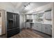 Updated kitchen with stainless steel fridge, grey cabinets, granite counters and hardwood style floors at 11323 Albion St, Thornton, CO 80233
