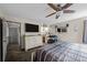 Cozy main bedroom featuring ceiling fan, TV, and ensuite bathroom with a view into a walk-in closet at 11323 Albion St, Thornton, CO 80233