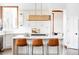 Bright kitchen with white cabinets, marble countertops, island with seating, and modern light fixture at 10260 Longview Dr, Lone Tree, CO 80124