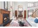 Open-concept living room with hardwood floors, a fireplace, and views of the entry foyer at 10260 Longview Dr, Lone Tree, CO 80124