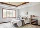 The primary bedroom has a large window, wood trim, and features a comfortable bed with bench seating at 10260 Longview Dr, Lone Tree, CO 80124
