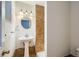 Bathroom with pedestal sink, tile surround, and updated fixtures at 3107 S Wolff St, Denver, CO 80236