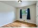 This bedroom features wood floors, natural light, and blue curtains at 3107 S Wolff St, Denver, CO 80236