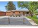 Charming single-story home showcasing a stone facade, orange trim, and well-maintained landscaping at 3107 S Wolff St, Denver, CO 80236