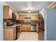 Efficient kitchen with stainless steel appliances, maple cabinetry, and tile floors at 3107 S Wolff St, Denver, CO 80236