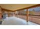 A covered patio with lattice and wooden railing, featuring tile flooring and seating at 3107 S Wolff St, Denver, CO 80236
