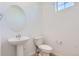 Well-lit half-bathroom featuring a pedestal sink, modern fixtures, and a sleek design at 712 N Bently St, Watkins, CO 80137