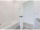 Clean bathroom featuring a white tiled shower-tub combo with an open door to the carpeted room at 712 N Bently St, Watkins, CO 80137