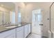 Modern bathroom featuring double sinks, gray countertops, and white cabinets at 712 N Bently St, Watkins, CO 80137