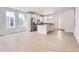 Open-concept kitchen with stainless steel appliances, white cabinets and island, and light wood floors at 712 N Bently St, Watkins, CO 80137