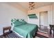 Cozy bedroom showcasing a green patterned comforter, unique lighting fixture, and neutral wall colors at 14321 E Tennessee Ave # 1-307, Aurora, CO 80012