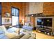 Inviting living area featuring exposed brick, comfortable seating, and a media center, creating a cozy atmosphere at 1450 Wynkoop St # 3F, Denver, CO 80202