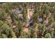 An aerial view of a home, with an adjacent garage, nestled among a thick forest at 32173 Soda Creek Dr, Evergreen, CO 80439