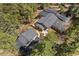 Aerial view of house and garage surrounded by trees, showing driveway and yard space at 32173 Soda Creek Dr, Evergreen, CO 80439