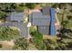 Property aerial showcasing roof with solar panels, large driveway, landscaping, and a peaceful natural setting at 32173 Soda Creek Dr, Evergreen, CO 80439