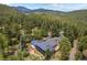 Breathtaking aerial shot of a secluded home with solar panels surrounded by nature, trees, and mountain views at 32173 Soda Creek Dr, Evergreen, CO 80439